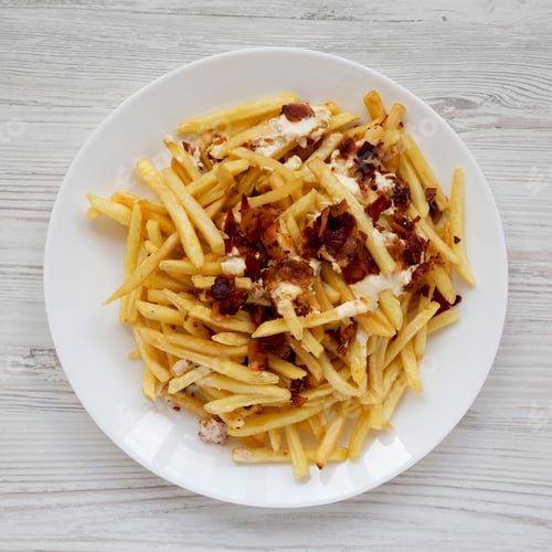 Preview: French Fries With Cheese Sauce And Bacon On A White Plate Over White Wooden Background, Top View