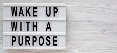 Preview: 'Wake Up With A Purpose' Words On A Modern Board On A White Wooden Surface, Top View. Overhead
