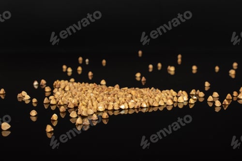 Preview: Lot Of Whole Common Raw Brown Buckwheat Grain Isolated On Black Glass