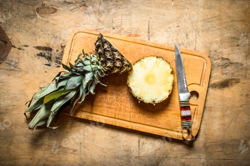Preview: Fresh Pineapple With A Knife. On A Wooden Table.