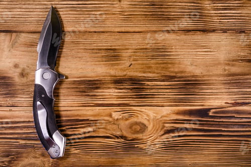 Preview: Opened Folding Knife On Rustic Wooden Table. Top View