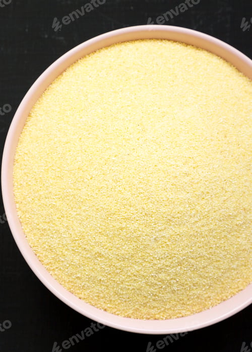 Preview: Dry Semolina Durum Flour In A Pink Bowl Over Black Surface, Overhead View. Top View, From Above
