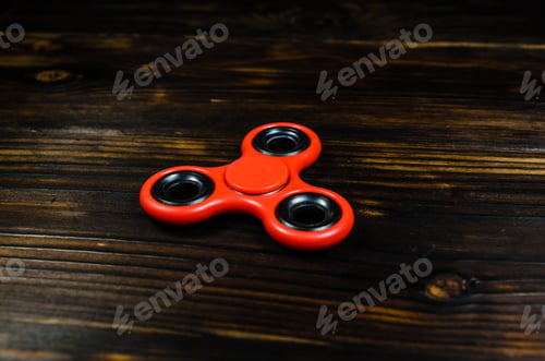 Preview: Red Fidget Spinner On Rustic Wooden Desk