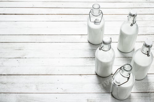 Preview: Fresh Milk In Bottles . On A White Wooden Table.