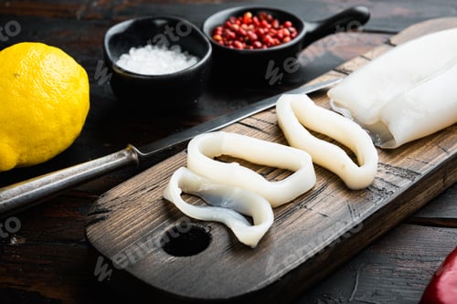 Preview: Raw Squid Meat On Wooden Cutting Board On Old Wooden Dark Table