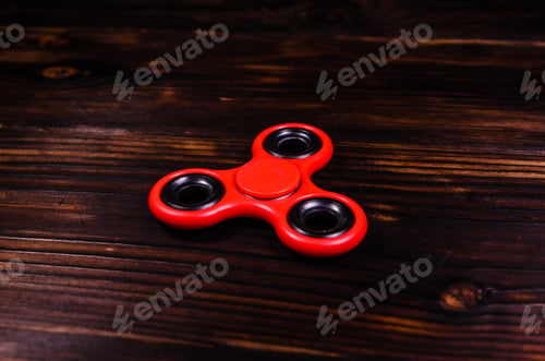 Preview: Red Fidget Spinner On Rustic Wooden Desk