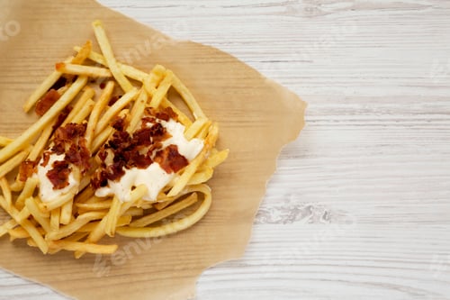 Preview: Tasty Fastfood: French Fries With Cheese Sauce And Bacon On A White Wooden Surface, Top View. Flat