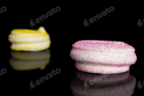 Preview: Group Of Two Whole Pink And Yellow Sweet Meringue Isolated On Black Glass