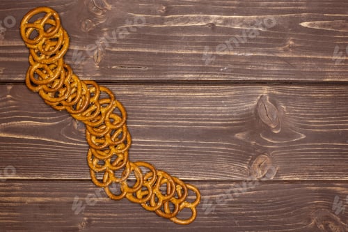 Preview: Lot Of Whole Mini Salted Pretzels Copyspace Flatlay On Brown Wood