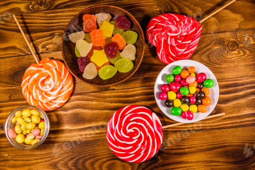 Preview: Different Sweet Candies On Rustic Wooden Table. Top View