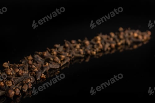 Preview: Lot Of Whole Dry Brown Clove Placed Diagonally Isolated On Black Glass