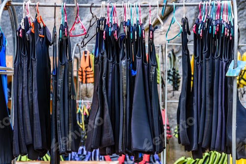 Preview: Many Diving Wetsuits On Hangers In Canyon