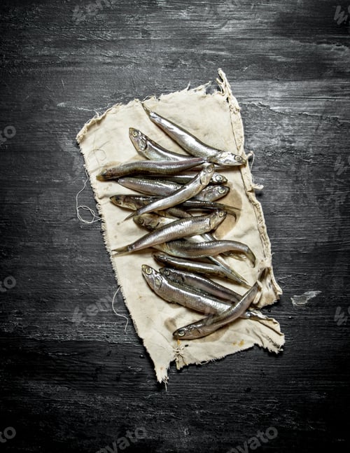 Preview: Sprat On The Old Fabric. On A Black Wooden Background.