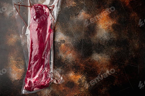 Preview: Fresh And Raw Beef Meat. Whole Piece Of Tenderloin In Vacuum Plastic Market Bag, On Old Dark Rustic