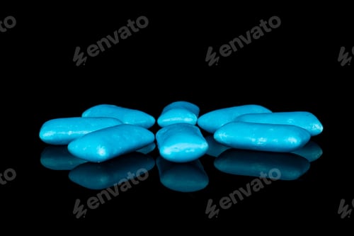 Preview: Group Of Eight Whole Blue Chewing Gum Isolated On Black Glass