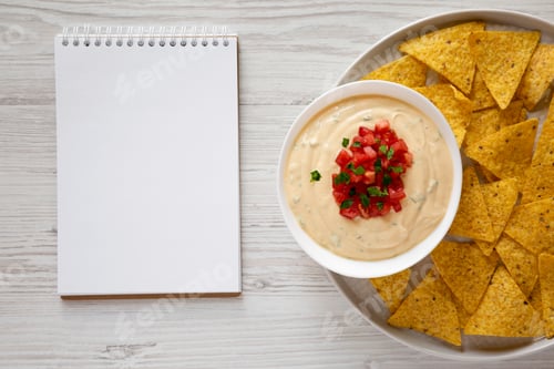 Preview: Homemade Cheesy Dip, Yellow Tortilla Chips With Blank Notepad Over White Wooden Background, Top