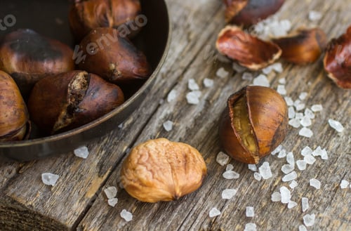 Preview: Roasted Chestnuts On Wooden Table With Coarse Salt