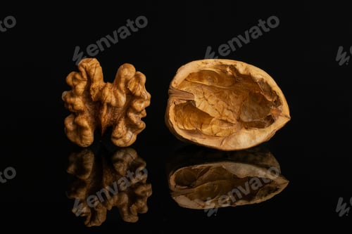 Preview: Group Of One Whole One Piece Of Ripe Brown Walnut Isolated On Black Glass