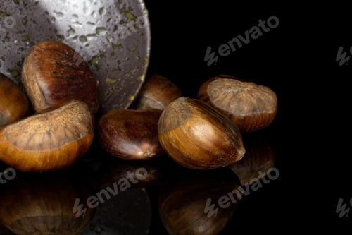 Preview: Group Of Seven Whole Edible Brown Chestnut In Glazed Bowl Isolated On Black Glass