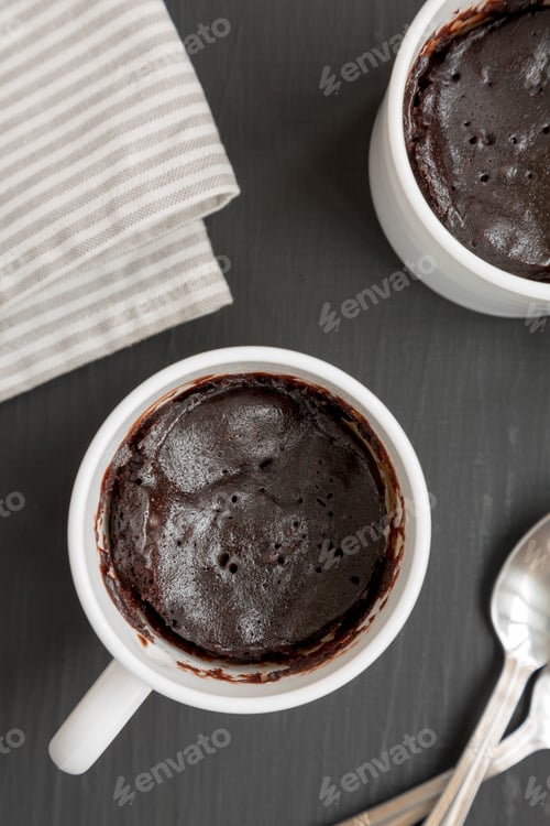 Preview: Homemade Brownie In A Mug On A Black Surface, Top View. Overhead, From Above, Flat Lay.