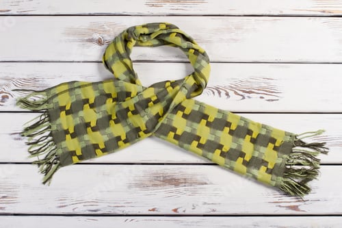 Preview: Beautiful Green Scarf On A Wooden Background. Warm Bright Winter Scarf.