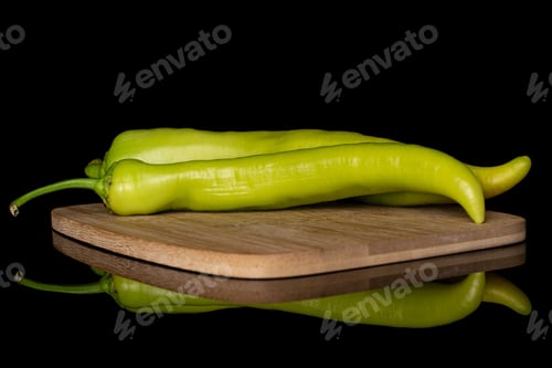 Preview: Group Of Two Whole Hot Green Pepper Banana On Bamboo Cutting Board Isolated On Black Glass