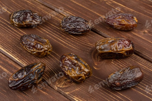 Preview: Group Of Eight Whole Dry Brown Date Fruit On Brown Wood