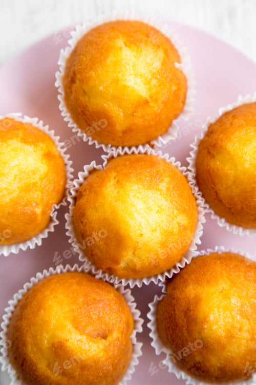Preview: Cupcakes On A Pink Plate Over White Wooden Surface, Overhead View. Closeup.