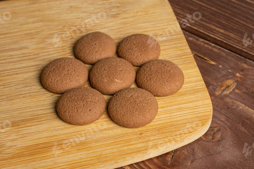 Preview: Group Of Seven Whole Sweet Brown Chocolate Sponge Biscuit On Bamboo Cutting Board On Brown Wood