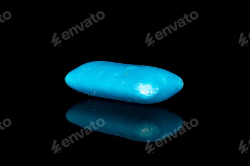 Preview: One Whole Blue Chewing Gum Isolated On Black Glass