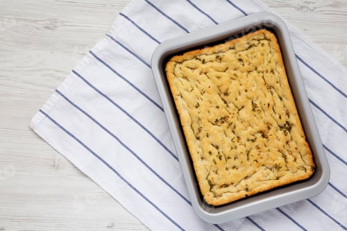 Preview: Home-Baked Rosemary Garlic Focaccia Bread On Baking Tray, Top View. Flat Lay, Overhead, From Above