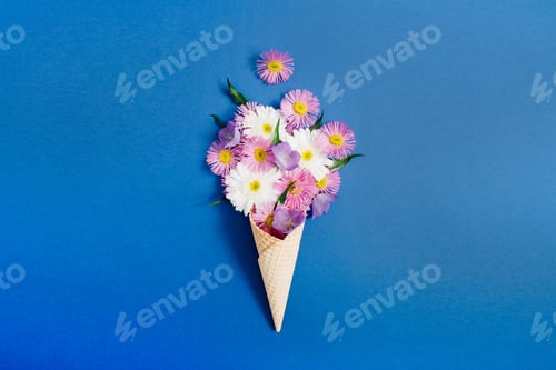 Preview: Waffle Cone With Chamomile Flower Bouquet On Blue Background. Flat Lay, Top View Floral Background.