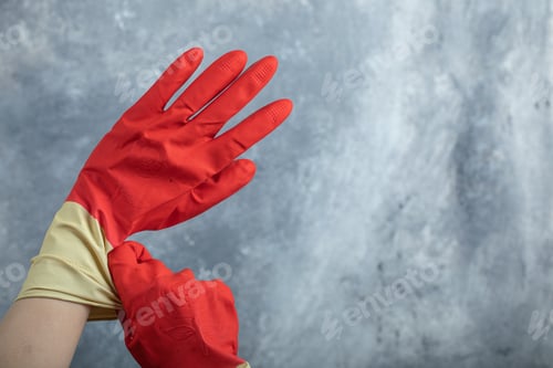 Preview: Hands Wearing Red Protective Gloves On Marble Background