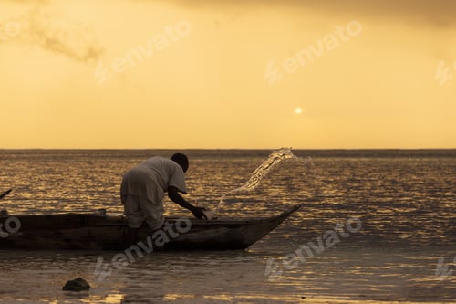 Preview: Silhouette Of Fisherman Preparing For Fishing At Sunrise In Zanzibar, Tanzania