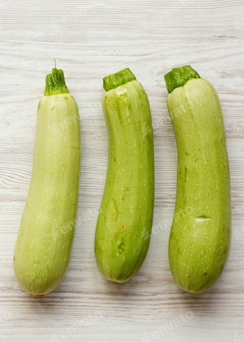 Preview: Fresh Vegetable Marrow Zucchini On White Wooden Table, Top View. From Above, Overhead. Close-Up.