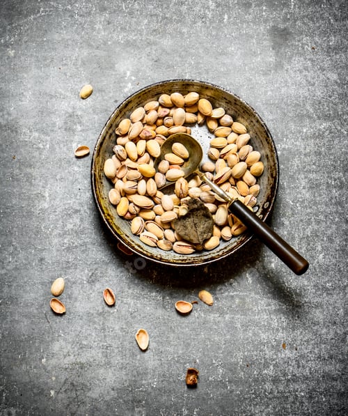 Preview: Pistachios In An Old Pan With A Ladle. On The Stone Table.