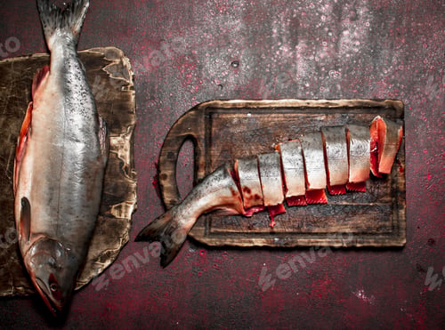 Preview: Cutting Fresh Salmon On A Cutting Board. On Rustic Background.