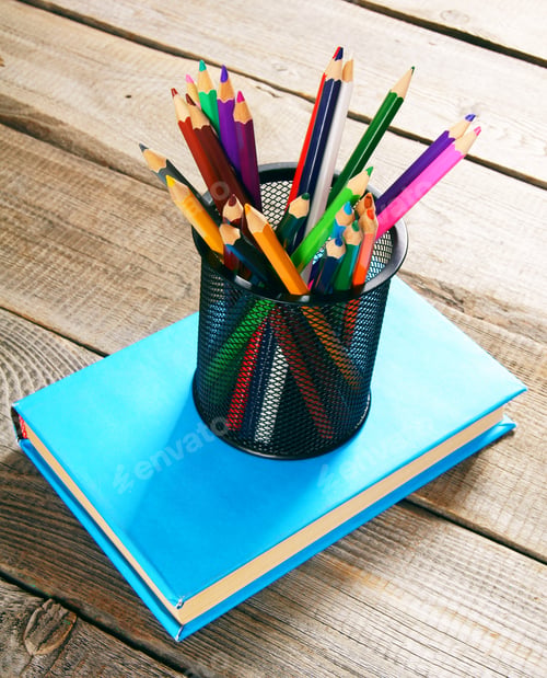 Preview: Pencils And Book . On A Wooden Background.