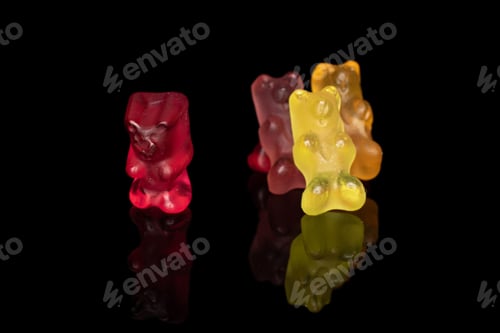 Preview: Group Of Four Whole Gummy Bear Isolated On Black Glass