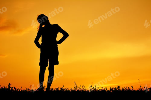 Vista previa: Silhouette Of Happy Girl Standing On Grass Field And Sky Sunset