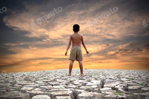 Preview: A Boy Standing On Dry Ground And Sky Background . Hope,Drought