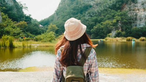 Preview: Cheerful Young Traveler Asian Lady With Backpack Walking At The Mountain Lake. Korean Teen Girl