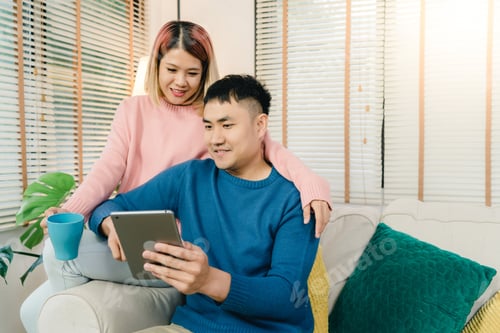 Preview: Smiling Couple Relaxing at Home with a Tablet