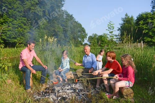 Preview: Multigenerational Family Cooking On Campfire In Field