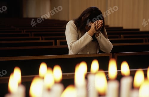 Preview: Close Up Of Candles Lit With Woman Praying In Church