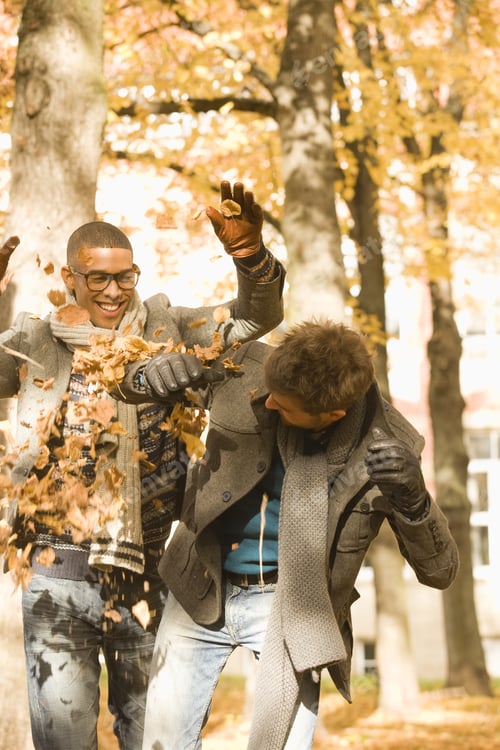 Preview: Young University Friends Throwing Autumn Leaves On College Campus