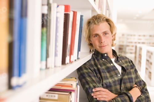Preview: Young Student Leaning Against Library Bookshelves, Portrait