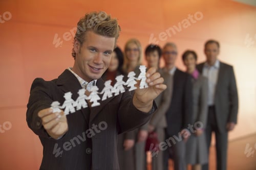 Preview: Group Of Businesspeople Posing With One Holding Paper Cutouts