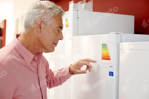 Preview: A Senior Man Looking At Fridge Freezers In An Electrical Shop