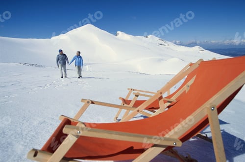 Preview: Couple Walking Toward Deck Chairs In Snow